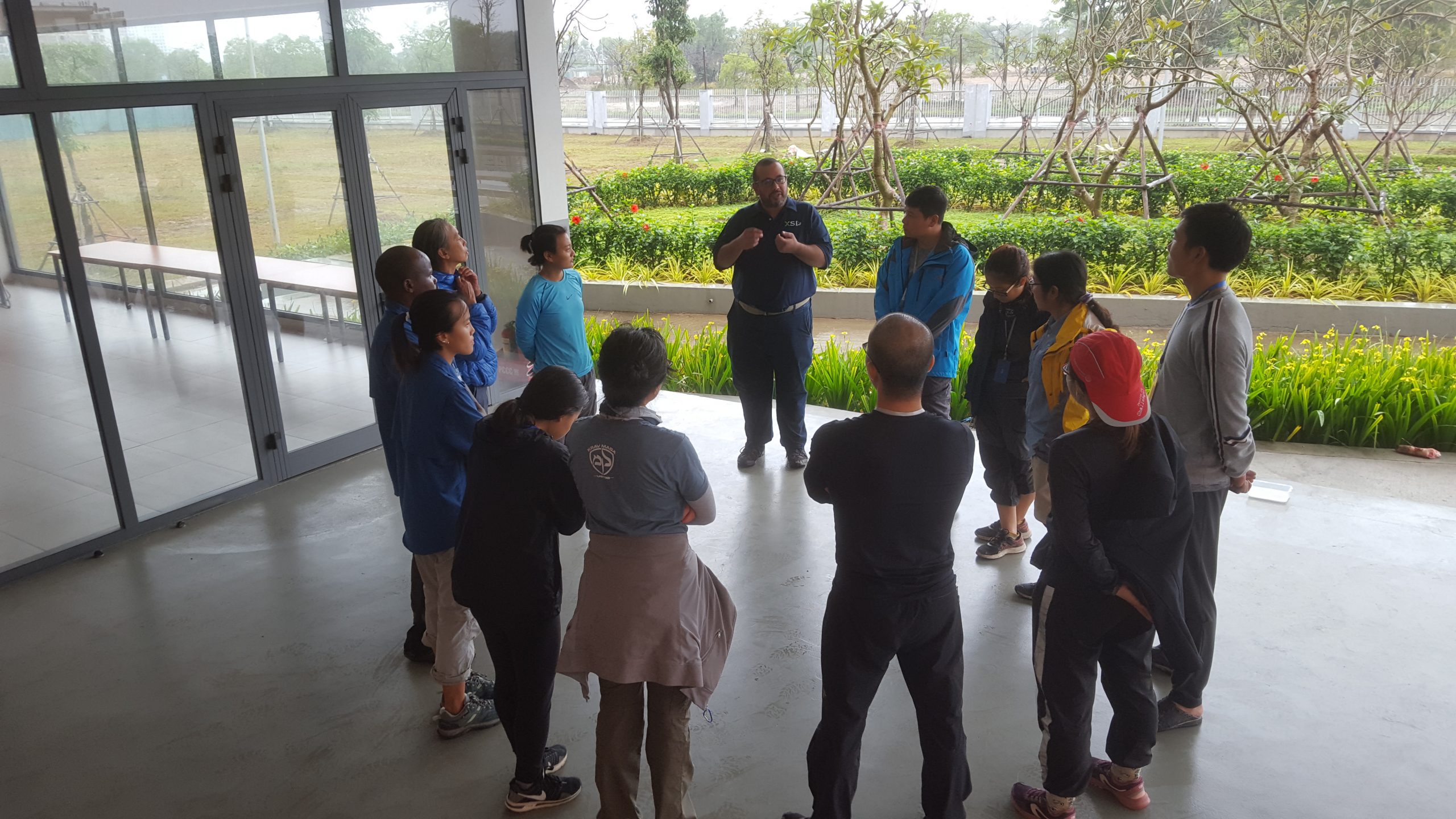 A picture of a group standing in a circle in a covered area.